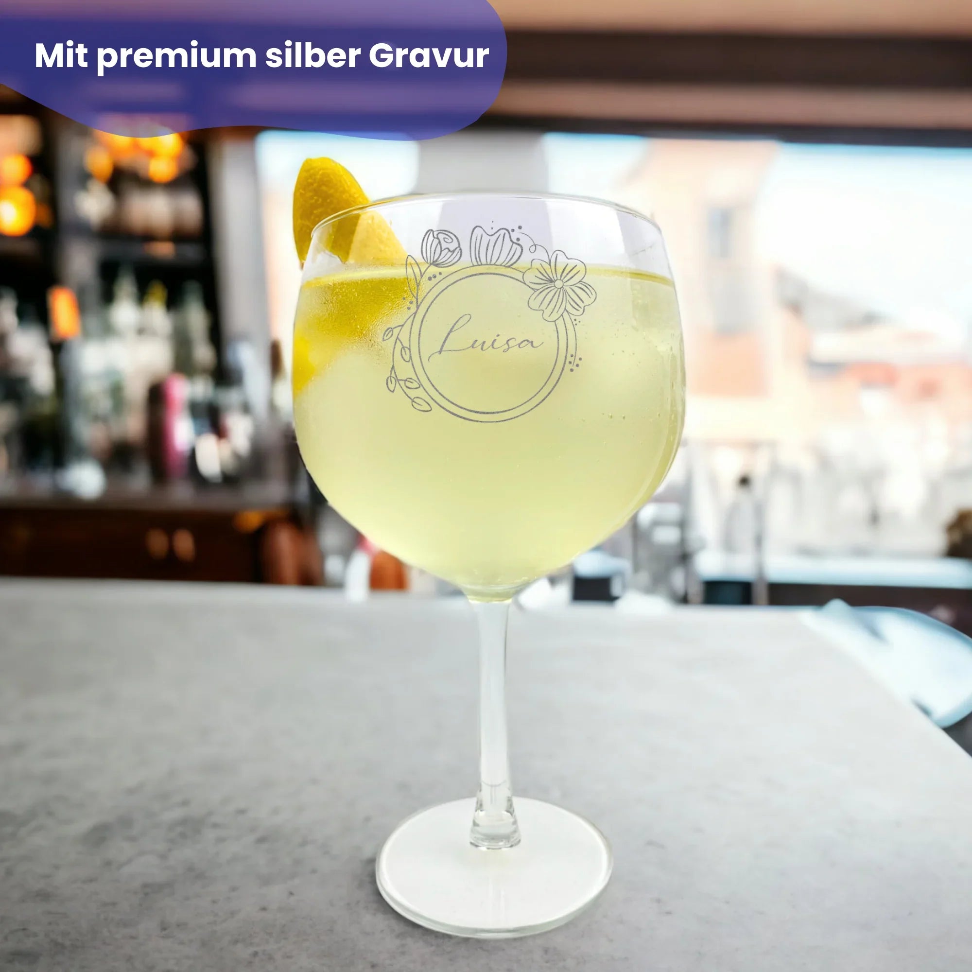 Gin-Glas mit Blumen- und Namensgravur, das auf einer Bar steht