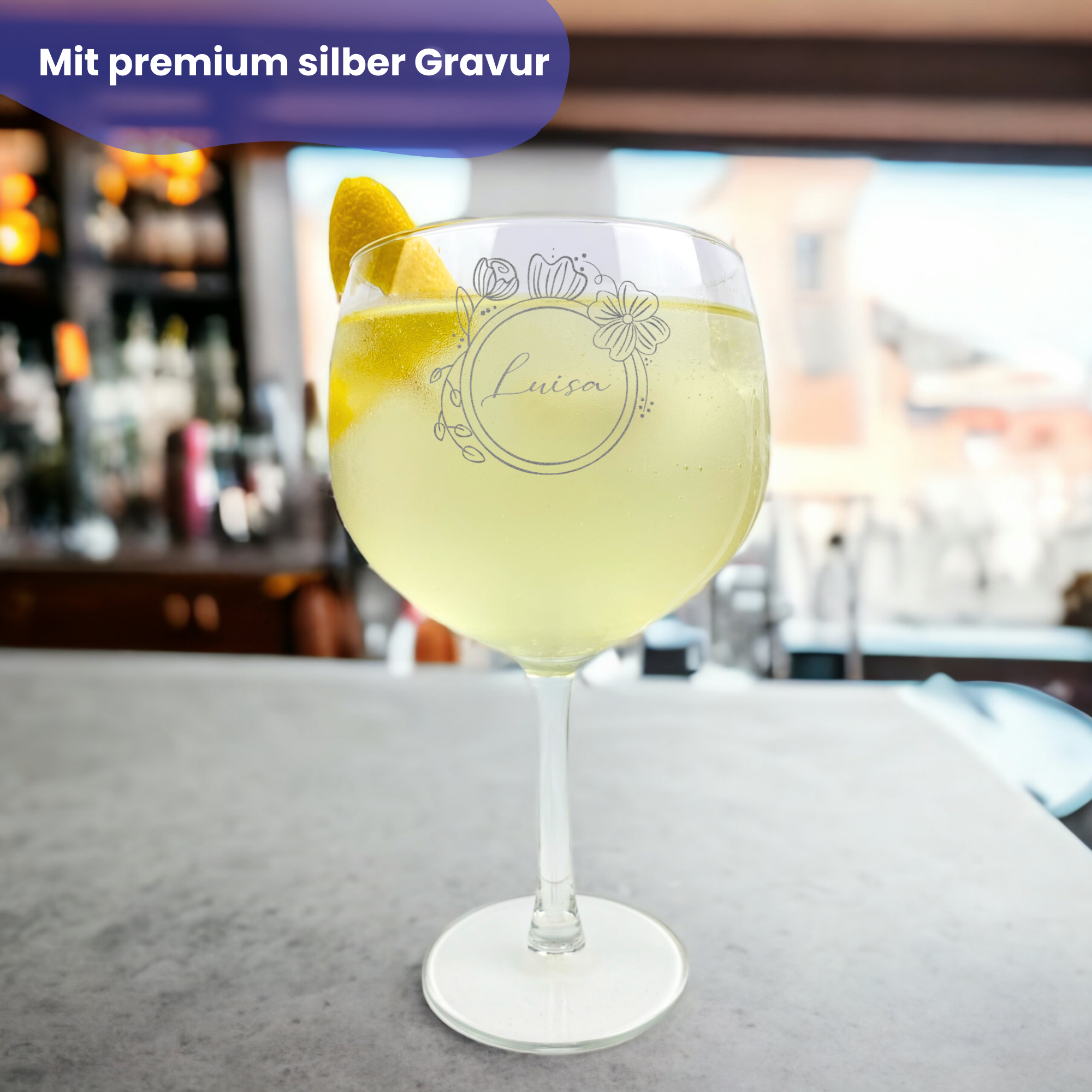 Gin-Glas mit Blumen- und Namensgravur, das auf einer Bar steht    